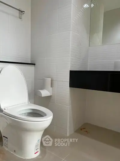 Modern bathroom with sleek white tiles and contemporary fixtures.