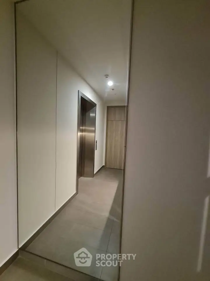 Modern apartment building elevator lobby with sleek design and neutral tones.