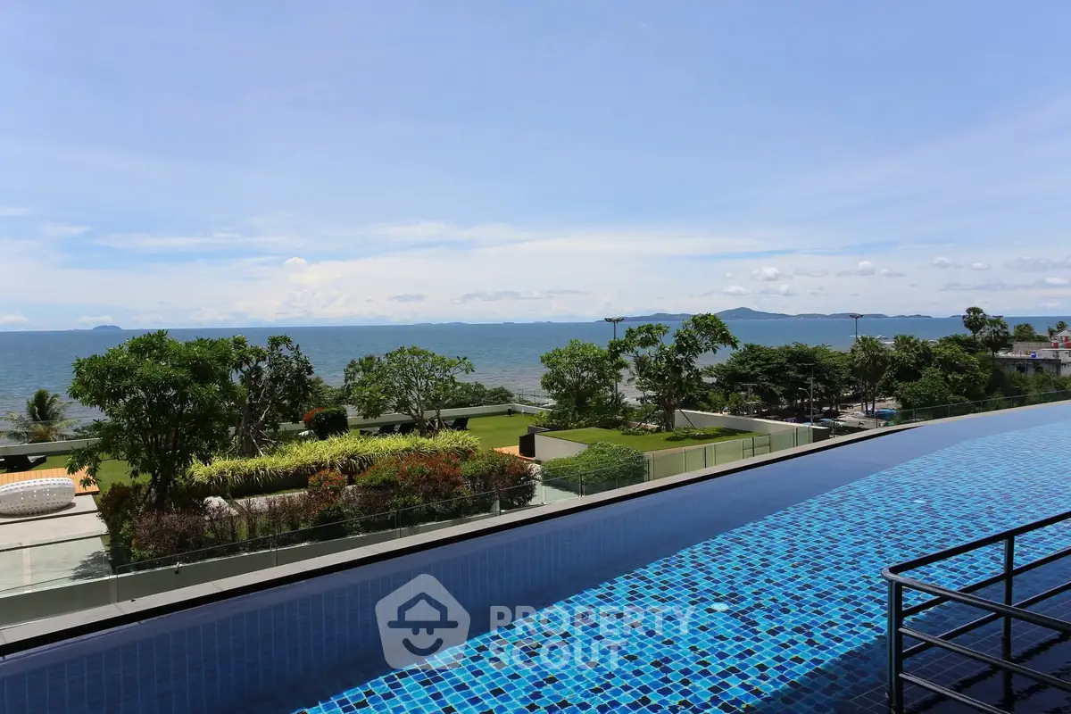 Stunning ocean view from rooftop pool with lush greenery and clear blue skies.