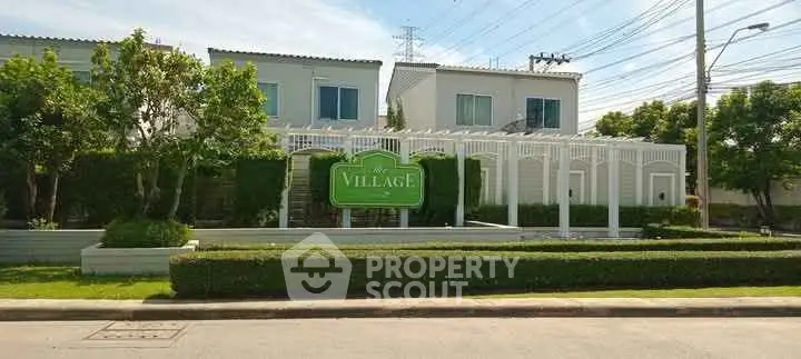 Charming residential community entrance with lush greenery and modern architecture.