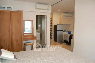 Cozy bedroom with ensuite bathroom and modern kitchen in a stylish apartment.