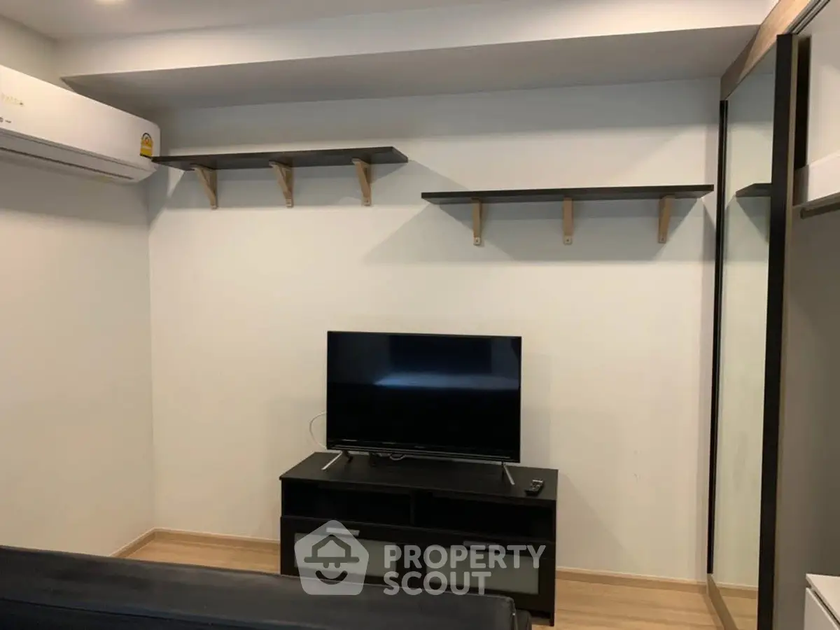 Modern living room with TV and sleek shelving, perfect for cozy entertainment.
