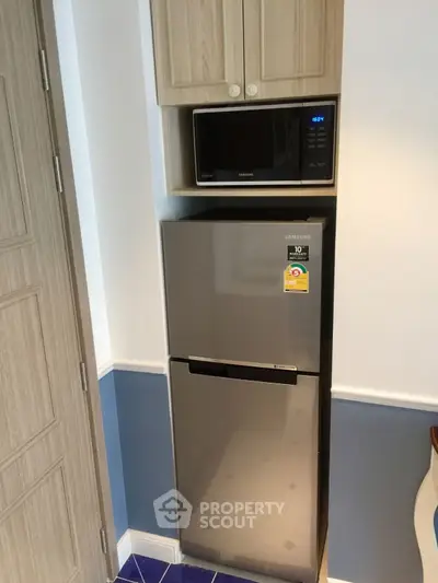 Modern kitchen corner with Samsung fridge and microwave in compact layout.