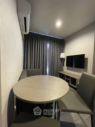 Modern living room with sleek furniture and wall-mounted TV in a cozy apartment setting.