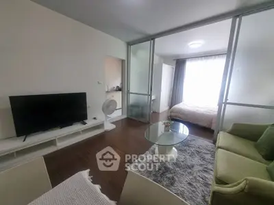 Modern living room with glass partition and cozy bedroom view