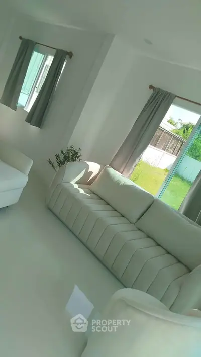 Spacious living room with modern white sofa and large windows for natural light