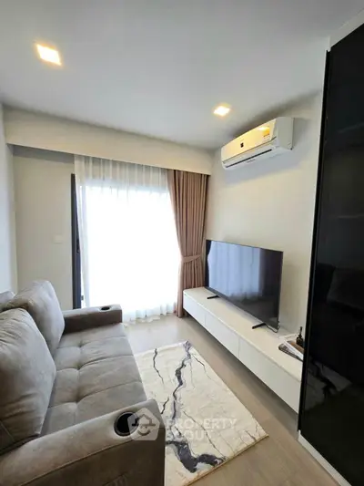 Modern living room with cozy sofa, flat-screen TV, and elegant decor