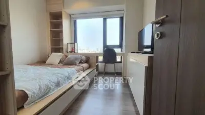 Cozy bedroom with city view, featuring modern furnishings and ample natural light.