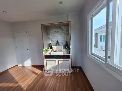 Bright room with wooden flooring and large window in modern home