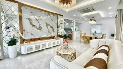 Luxurious living room with elegant decor and open layout, featuring marble accents and modern furnishings.