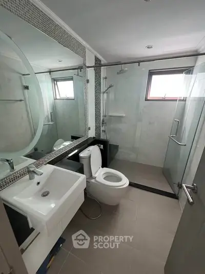Modern bathroom with glass shower and sleek fixtures in a contemporary apartment.