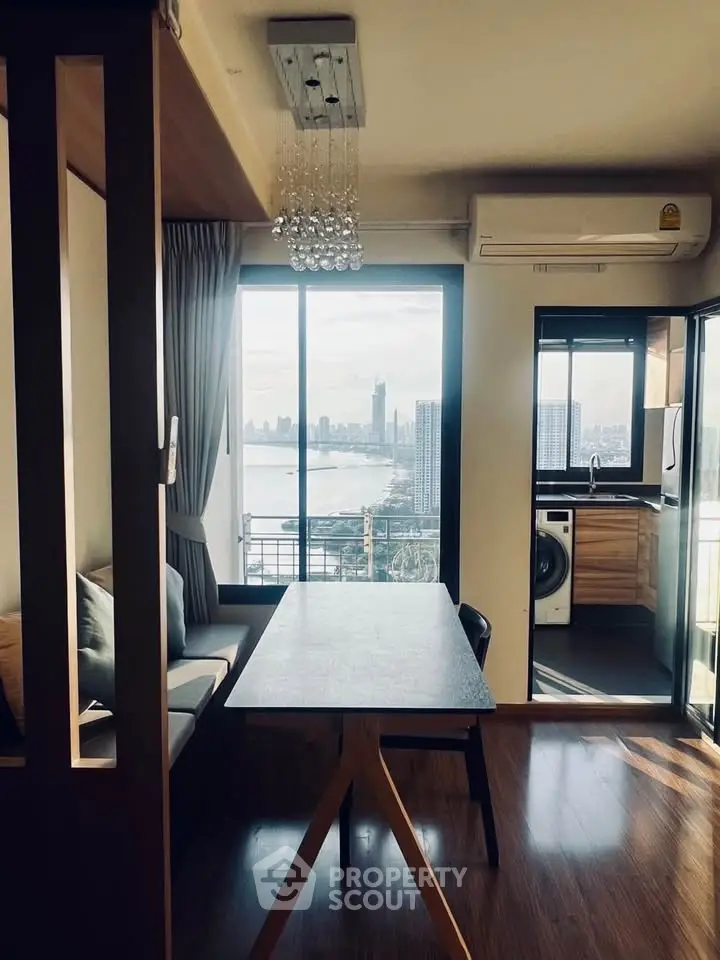 Modern dining area with stunning city view and adjacent kitchen featuring washing machine.