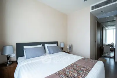 Spacious bedroom with modern decor and natural light, featuring a comfortable bed and stylish furnishings.