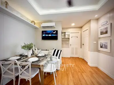 Chic modern living room with dining area, featuring stylish decor and warm wooden flooring.