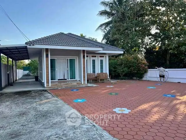 Charming single-story home with spacious driveway and lush greenery, perfect for serene living.