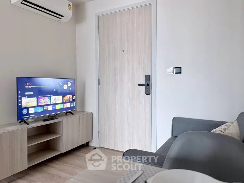 Modern living room with sleek furniture and smart TV in a cozy apartment.