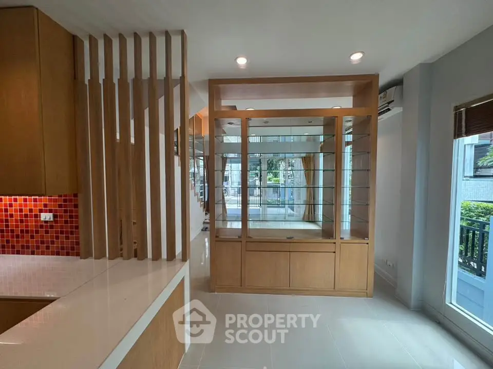 Spacious modern living area with wooden accents and large windows for natural light.