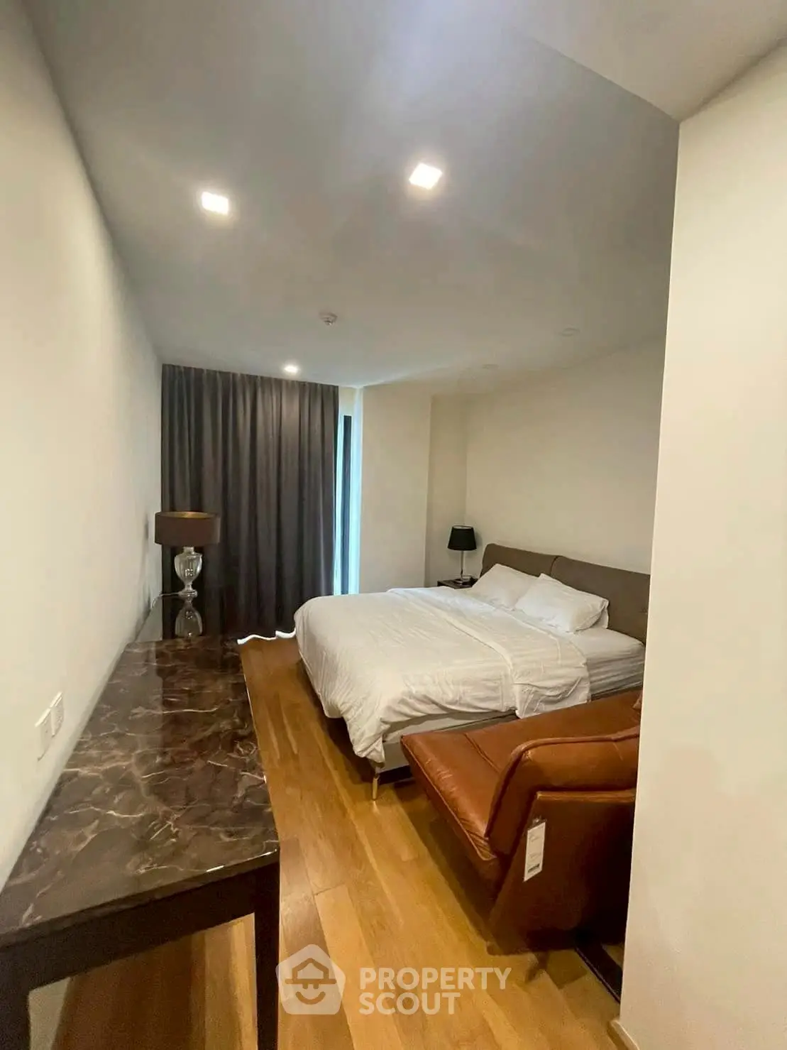 Modern bedroom with cozy bed, elegant lighting, and stylish decor in a contemporary apartment.