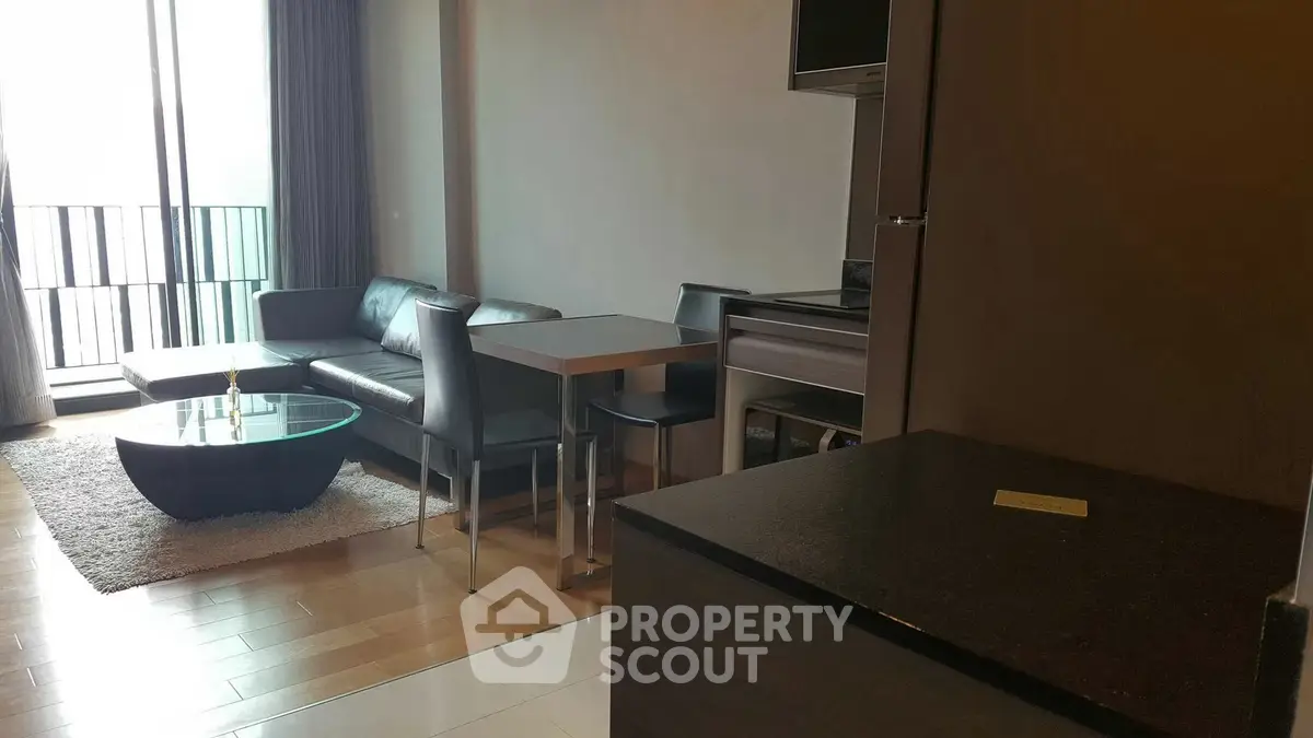 Modern living room with sleek furniture and open kitchen layout in a stylish apartment.