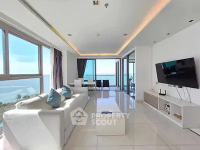 Luxurious living room with ocean view, modern decor, and ample natural light.