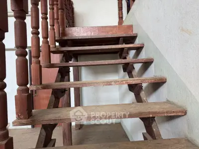 Rustic wooden staircase with classic balustrades in a cozy home interior.