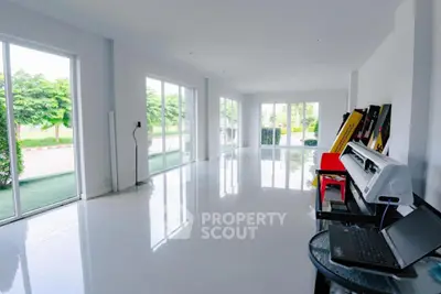 Spacious modern living room with large windows and glossy white flooring