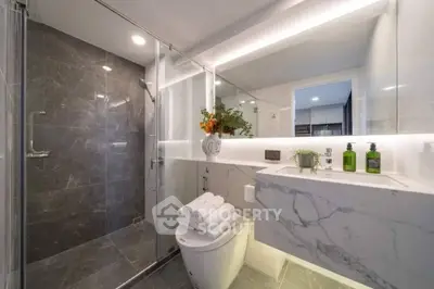 Luxurious modern bathroom with marble finishes and glass shower enclosure