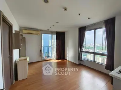 Spacious corner unit with big windows and city view, featuring wooden flooring and modern design.