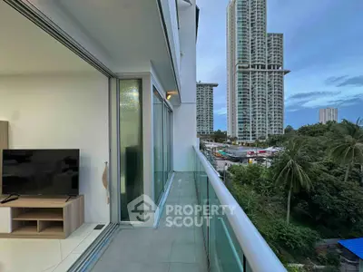 Modern condo balcony with stunning city view and lush greenery, perfect for urban living.