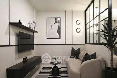 Modern living room with stylish decor, featuring a cozy sofa, wall-mounted TV, and elegant black-and-white accents.