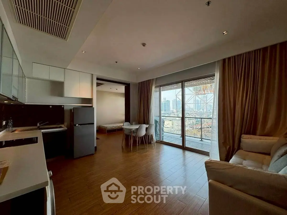 Modern open-plan living room with city view balcony in high-rise apartment.