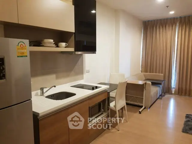 Modern kitchen with open layout and cozy living area in a stylish apartment.