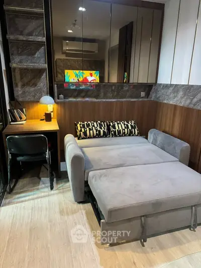 Modern living room with stylish sofa bed and workspace, perfect for urban living.