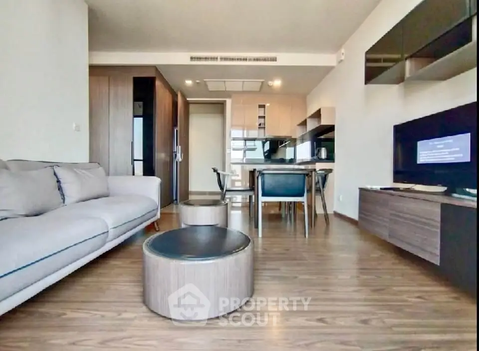 Modern open-plan living room with stylish furniture and kitchen area, perfect for contemporary living.