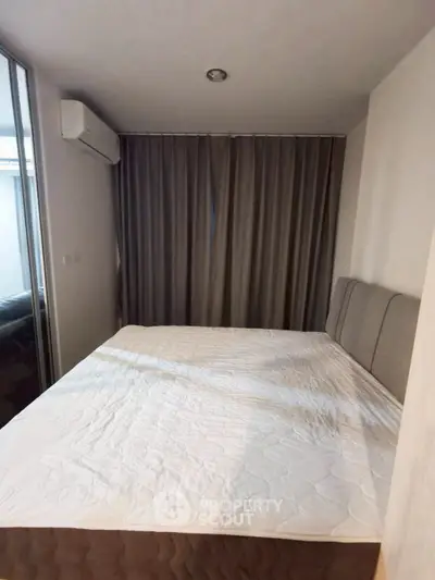 Cozy bedroom with modern design and large bed, featuring elegant curtains and air conditioning.