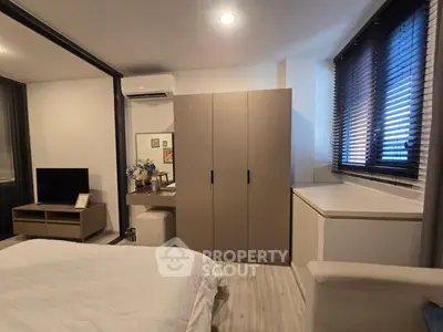 Modern bedroom with sleek furniture and natural light, featuring a cozy bed, wardrobe, and stylish decor.