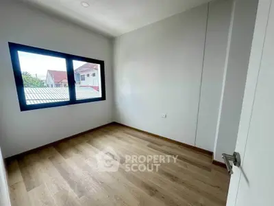 Bright empty room with wooden flooring and large window view