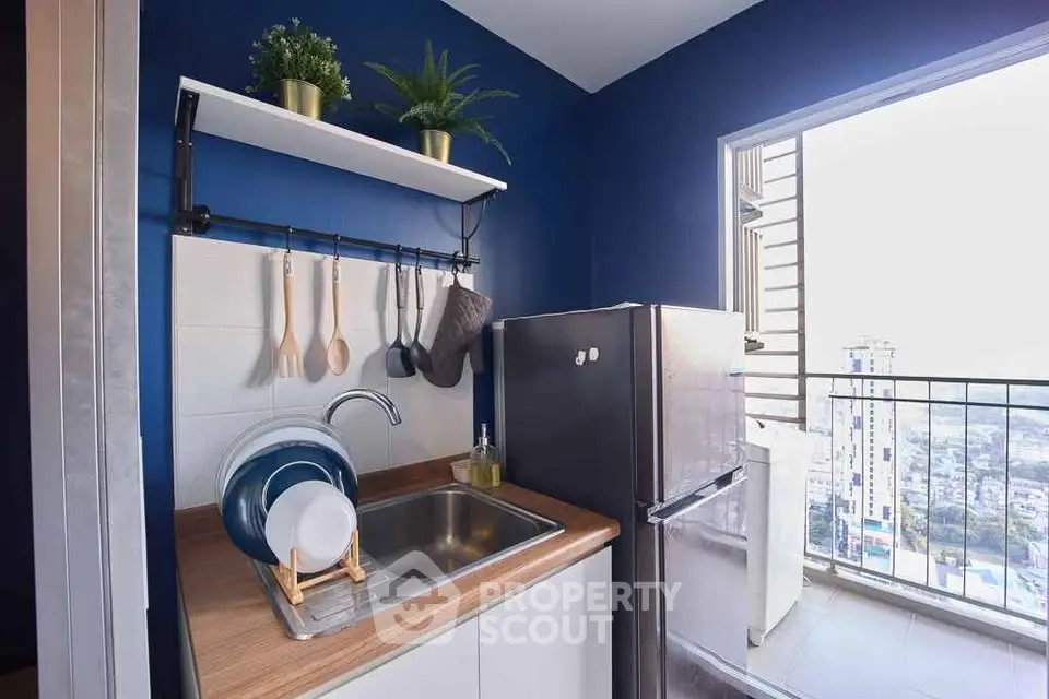 Charming kitchen with blue walls and balcony view in modern apartment