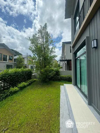 Modern suburban home with lush green garden and large windows