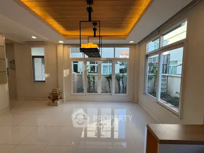 Spacious modern living room with large windows and elegant lighting