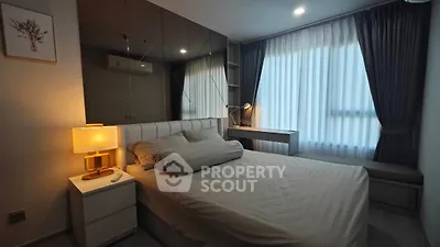 Modern bedroom with stylish decor and large window for natural light.