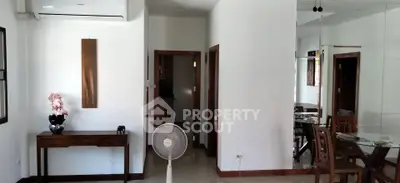 Spacious living room with modern decor and dining area, featuring air conditioning and elegant furniture.