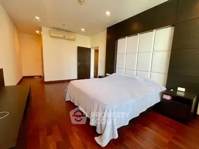 Spacious bedroom with modern decor and hardwood flooring