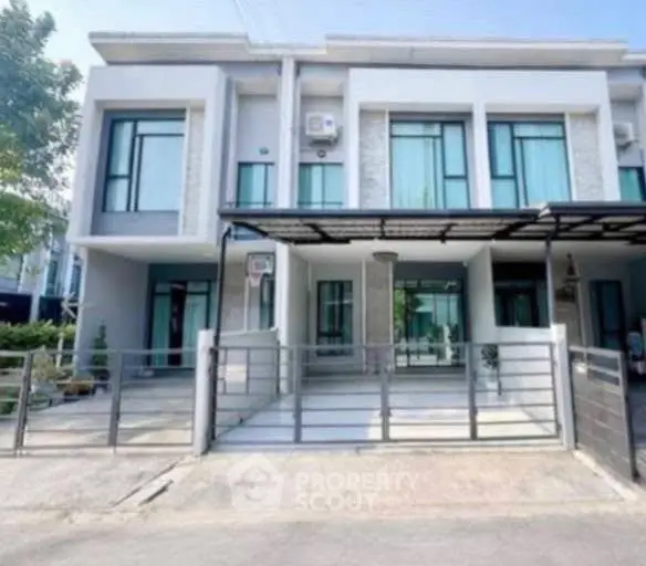 Modern townhouse exterior with sleek design and gated entrance in a suburban neighborhood.
