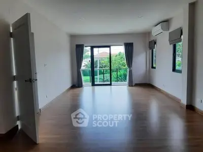 Spacious empty living room with large windows and wooden flooring