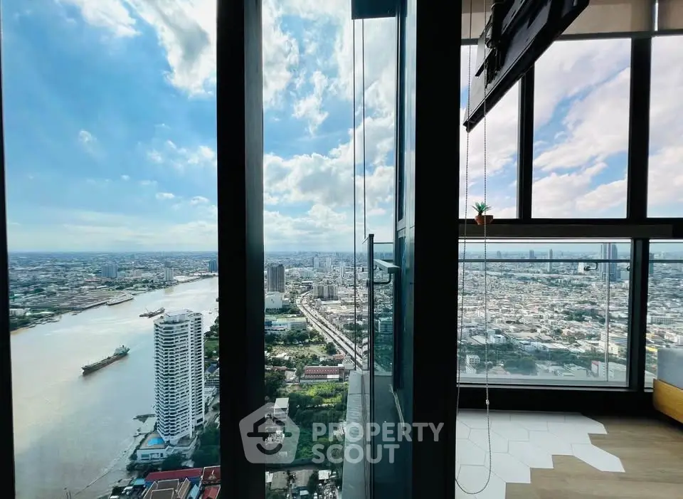 Stunning high-rise view of city skyline and river from modern apartment with floor-to-ceiling windows.