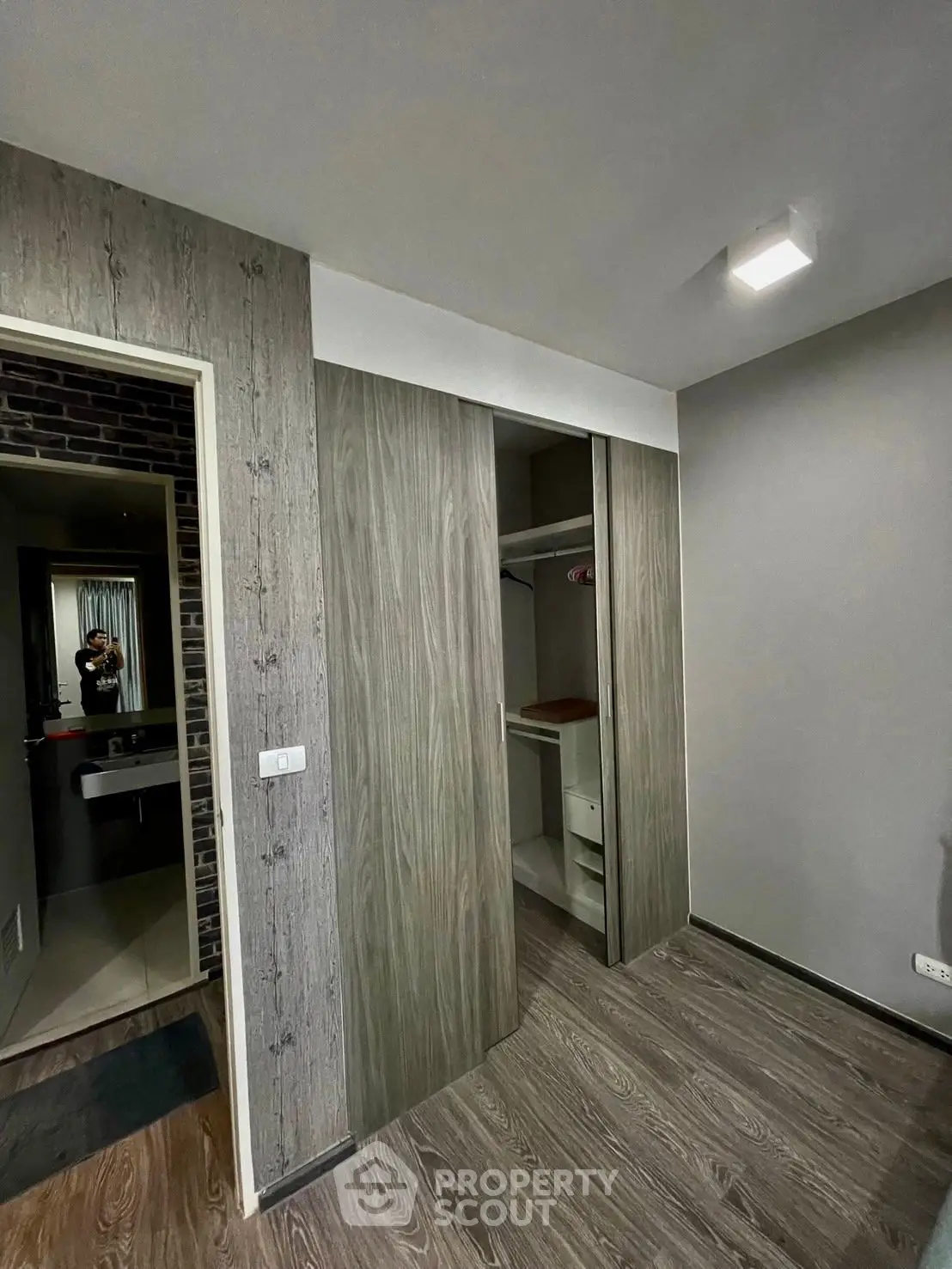 Modern bedroom with stylish wooden closet and sleek flooring