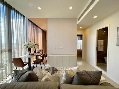Modern living room with elegant dining area and floor-to-ceiling windows