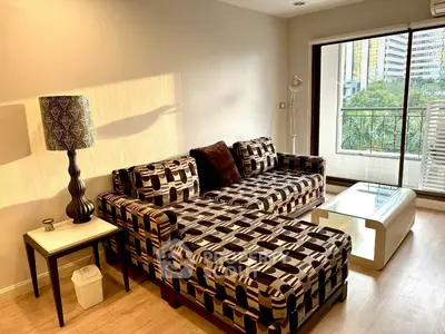 Stylish living room with modern sofa and city view balcony, perfect for urban living.