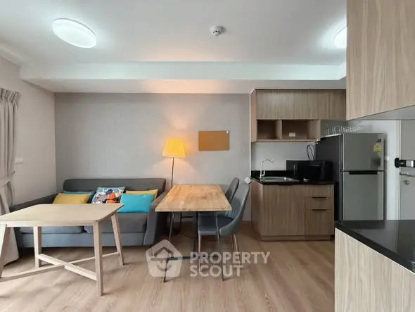 Modern living room with open kitchen, cozy seating, and stylish decor